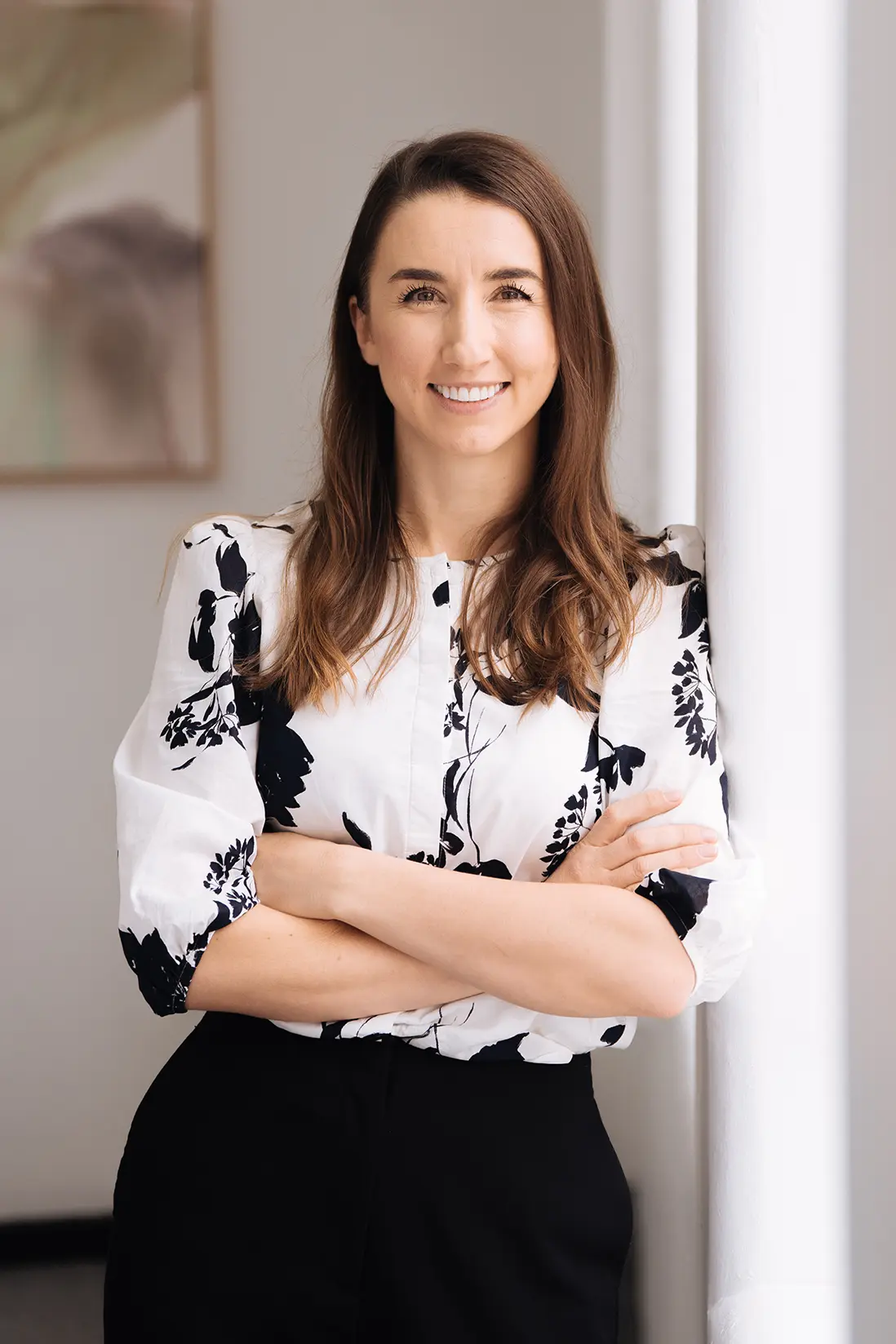 Jessica_Rossi Jessica Rossi, Accountant, smiling while leaning against a wall of a light-filled, elegant room
