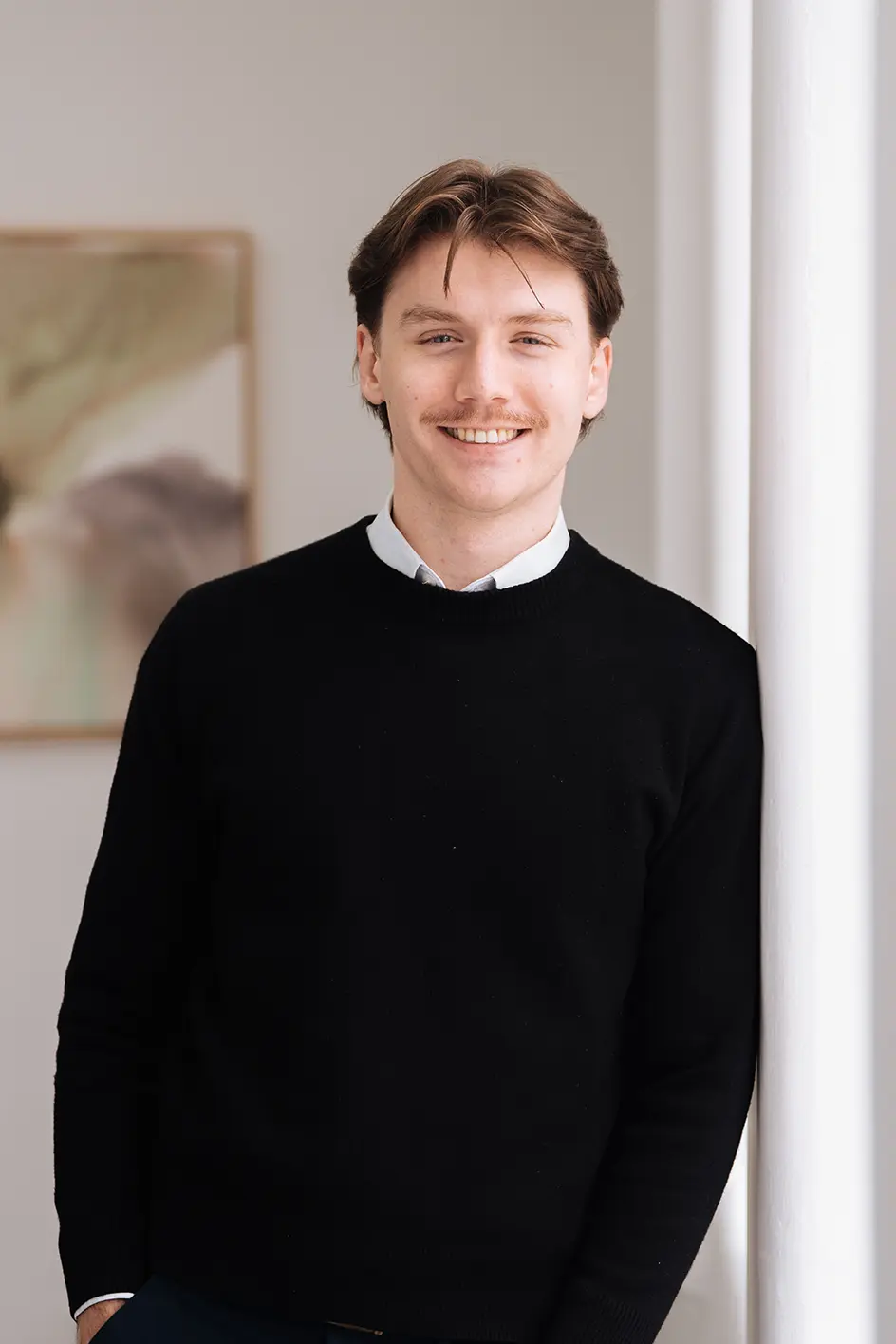 Xavier_Borg Xavier Borg, Accountant, smiling while leaning against a wall of a light-filled, elegant room